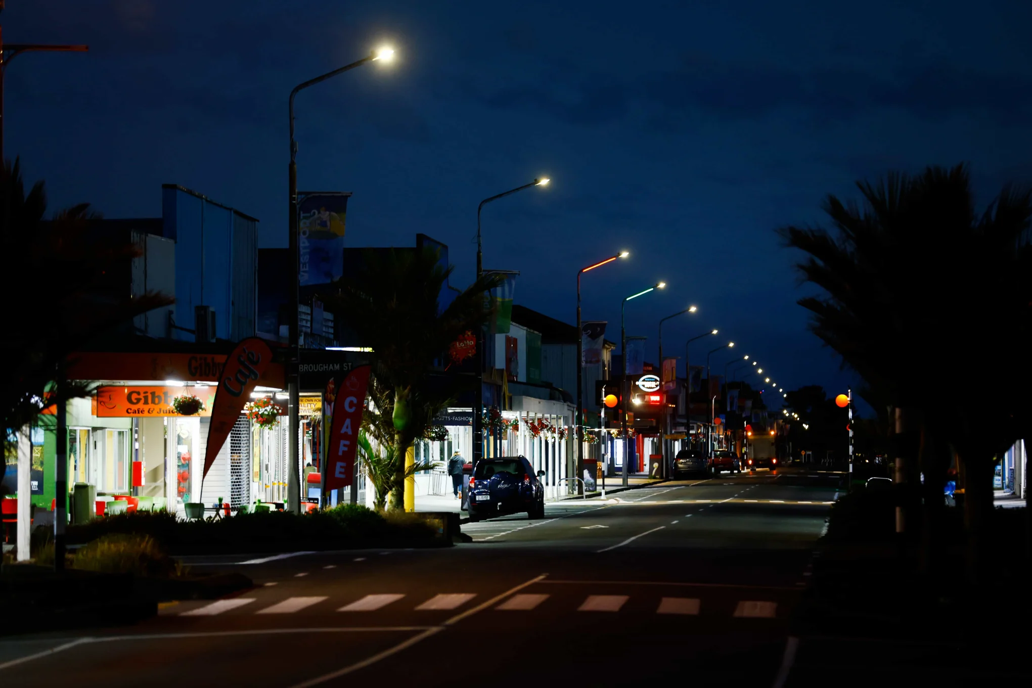 street lights and lit shops along a dark street